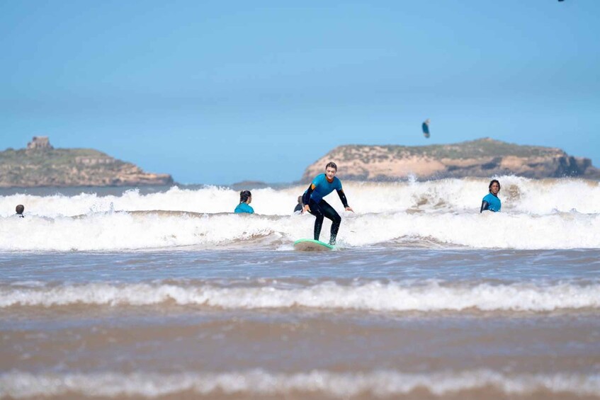A surfer riding a wave with a coastal landscape in the background. 2