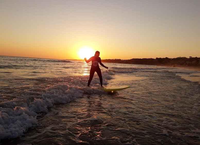 A person surfing on a wave at sunset. 1