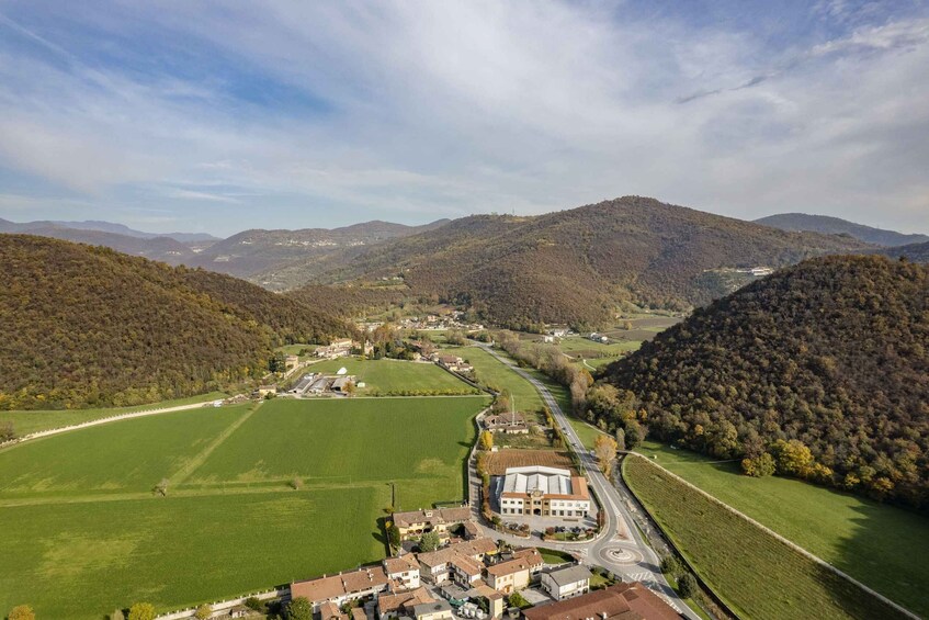 A valley with a town nestled among rolling hills, surrounded by fields and forests. 3