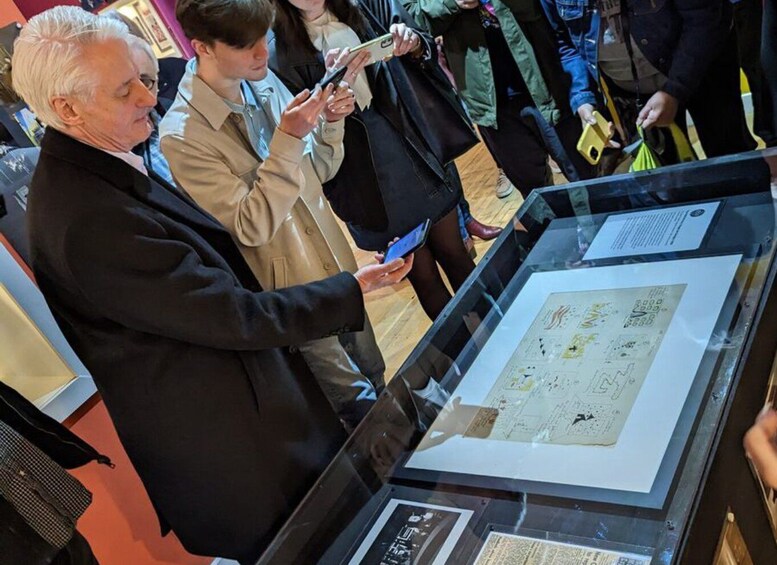 A museum exhibit with a glass display case containing documents and a map. 4