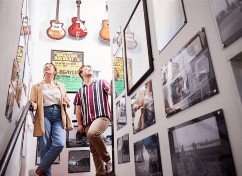 A corridor with guitars hanging on the wall and framed pictures on the sides. 2