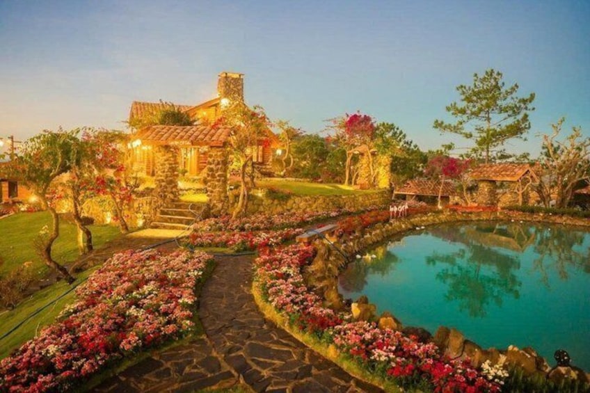 A stone house with a garden, a pond, and a pathway. 4