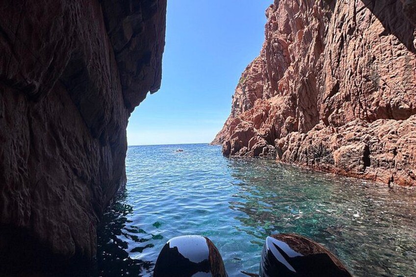 A rocky coastline with clear blue water and a boat in the foreground. 2