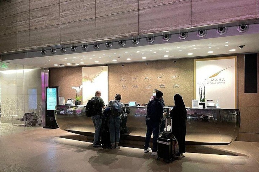 A reception area with a digital information kiosk, a reception desk, and a wall with floral decorations. 2