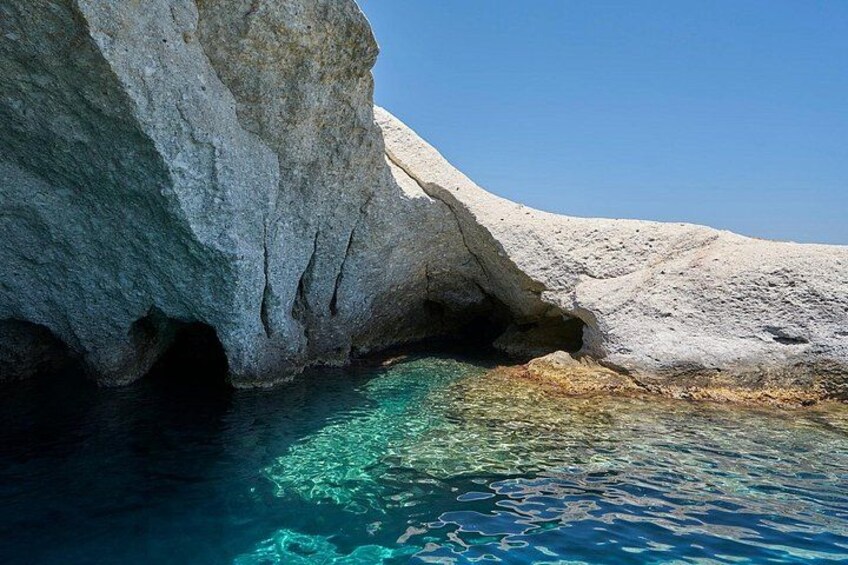 Una costa rocciosa con acque blu cristalline e una formazione rocciosa bianca. 3