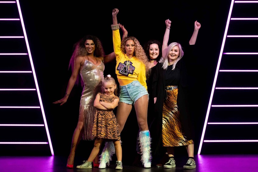 A group of people on a stage with neon lights. 3