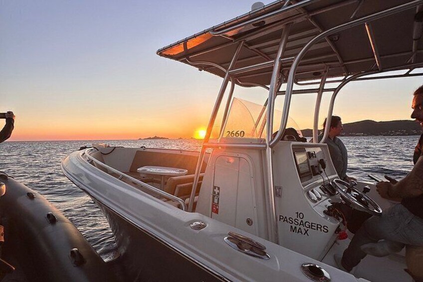 A boat with a '10 PASSAGERS MAX' sign, a steering wheel, and a person at the helm. 3