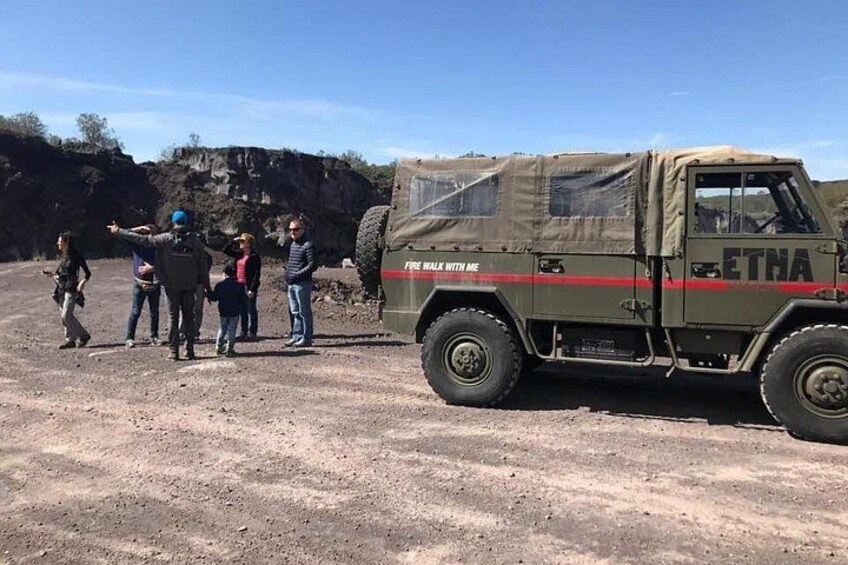 Ein Militärfahrzeug mit den Aufschriften 'FIRE WALK WITH ME' und 'ETHNA', das auf einer unbefestigten Straße steht, wobei sich Menschen in der Nähe aufhalten. 4