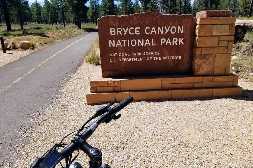 Un panneau indiquant le parc national de Bryce Canyon, avec une route de gravier au premier plan. 1