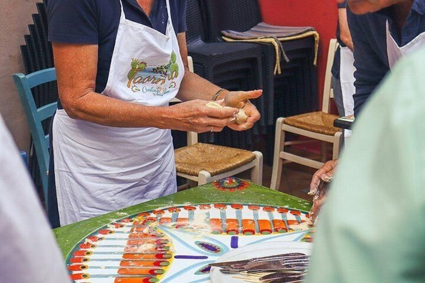 Iemand maakt eten, draagt een schort met een logo en staat bij een tafel met een vrolijk ontwerp. 1