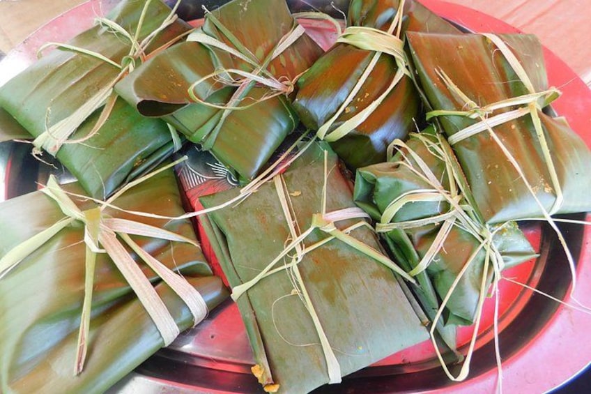 A collection of food items wrapped in leaves, tied with strings. 5