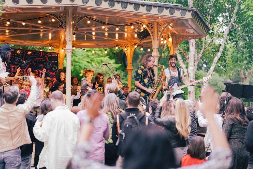 A gazebo with a band performing, surrounded by an audience. 5