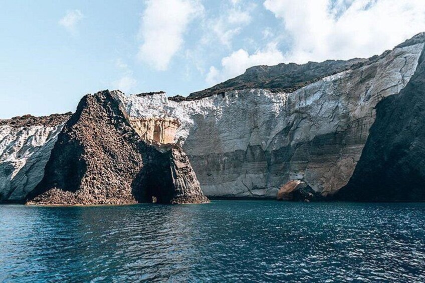 A coastal landscape with a prominent rock formation and a cliff. 3