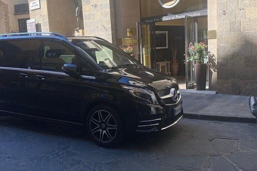 En svart bil stod parkerad på en kullerstensgata framför en byggnad med en skylt som visade texten ”Hotel Pizzeria Palace al Ponte Vecchio”. 4