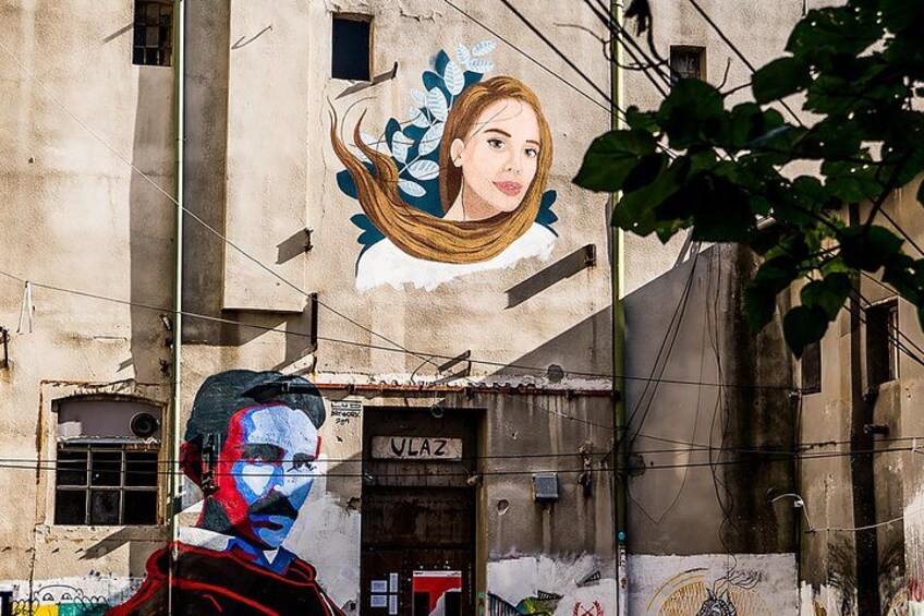 A mural on a building, a man with a painted face, and a door labeled 'VLAZ'. 1