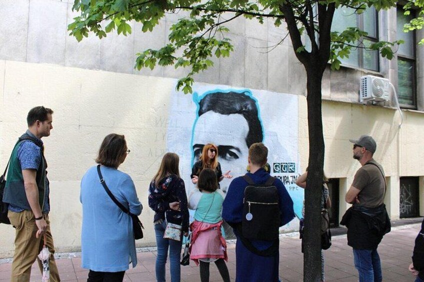 A mural on a wall with people standing in front of it. 4
