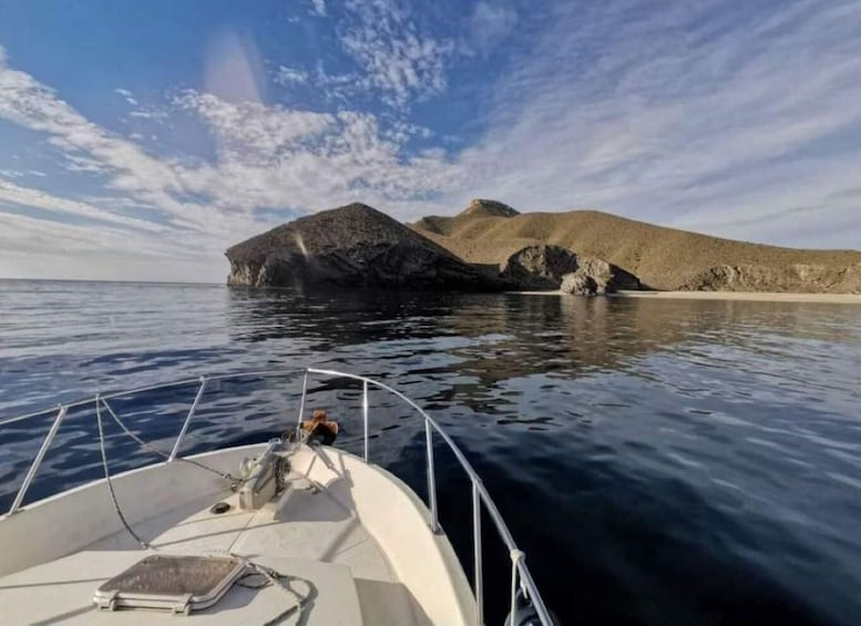 A boat on calm water with a rocky island in the distance. 5