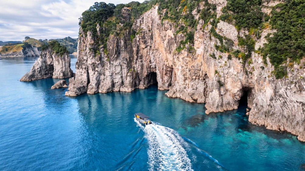 A boat navigating through a narrow waterway flanked by rocky cliffs. 3