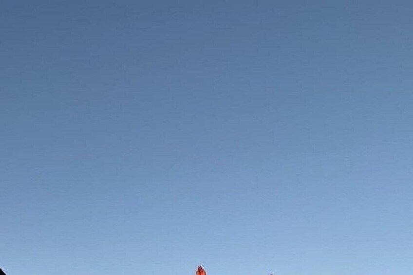 A clear blue sky with a small red object visible in the distance. 2