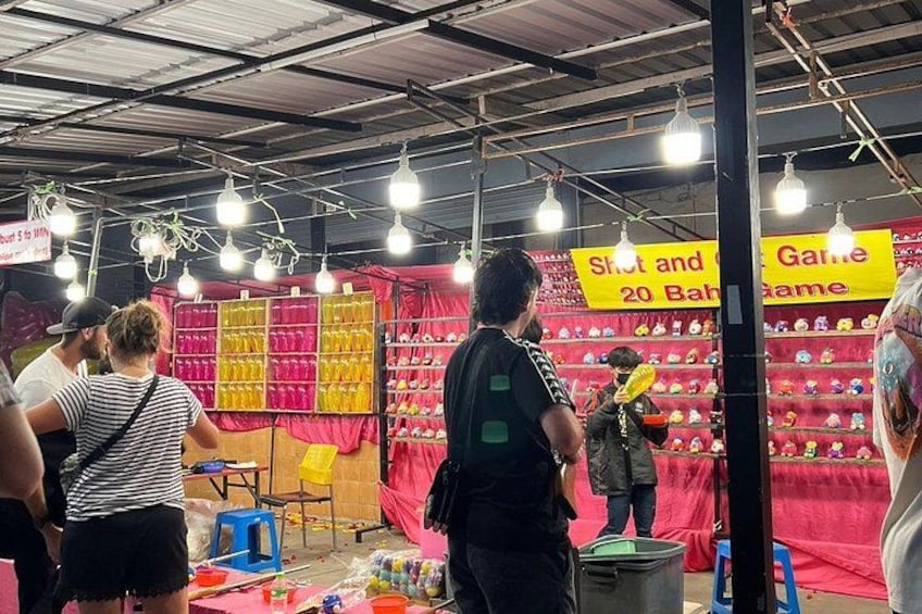 A market stall with colorful displays and signs advertising games. 2