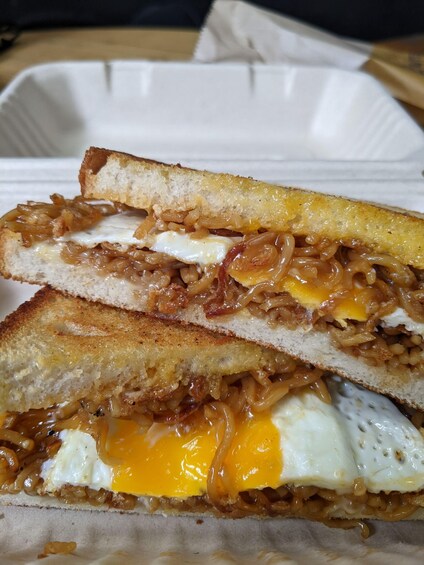 A grilled sandwich with melted cheese and a fried egg. 2