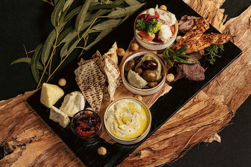 A charcuterie board with various cheeses, olives, and meats. 1