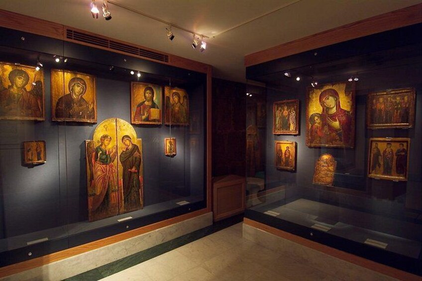 A museum interior with glass display cases containing religious icon paintings. 3