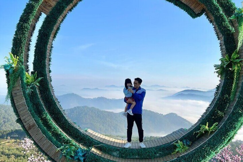 A couple standing in a circular garden with a view of mountains. 5
