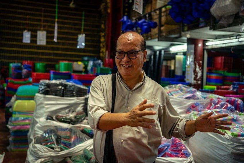 Une personne se trouve dans un entrepôt où des étagères sont remplies de boîtes en plastique de différentes couleurs. 4
