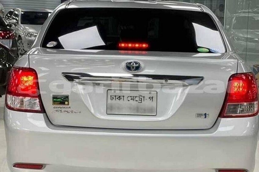 A white Toyota Corolla with a visible license plate and a rear spoiler. 4