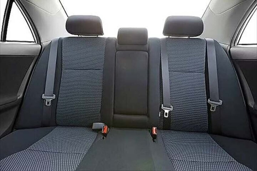 A car interior with three seats, seat belts, and a central console. 5
