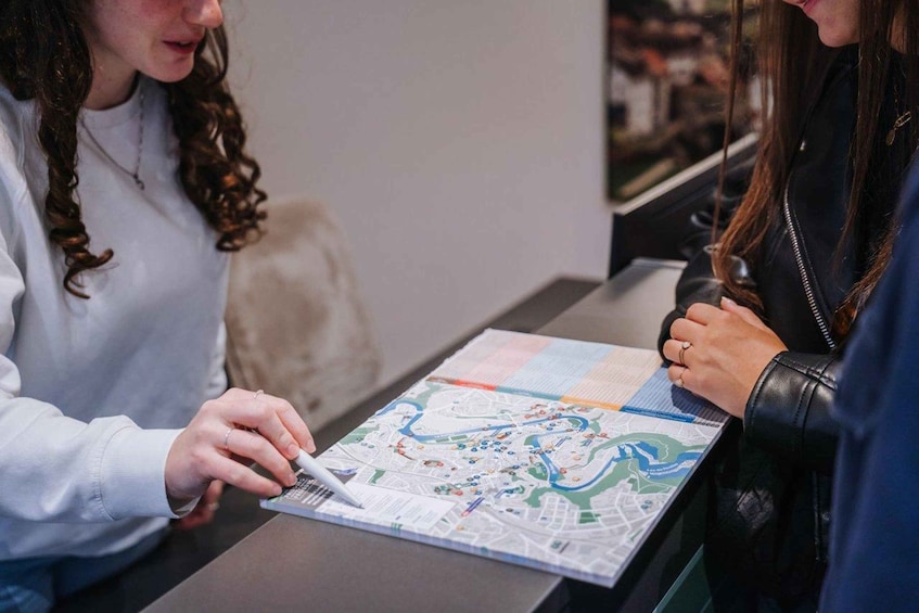 Two individuals examining a map with a city layout and transportation routes. 5