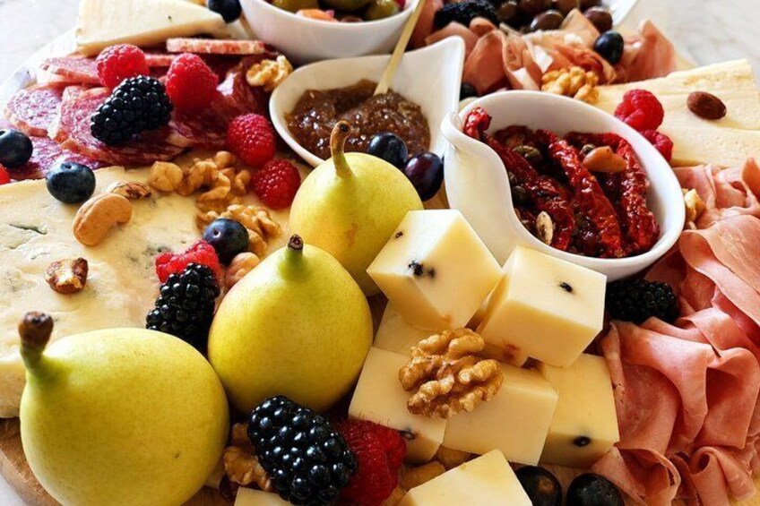 A charcuterie board with cheese, fruits, nuts, and meats. 3
