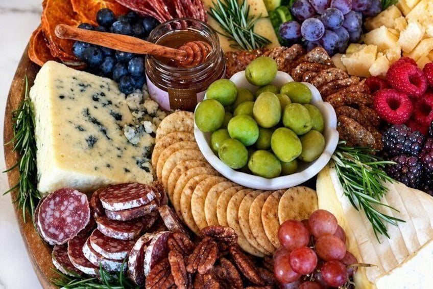 A charcuterie board with various cheeses, fruits, nuts, and crackers. 1