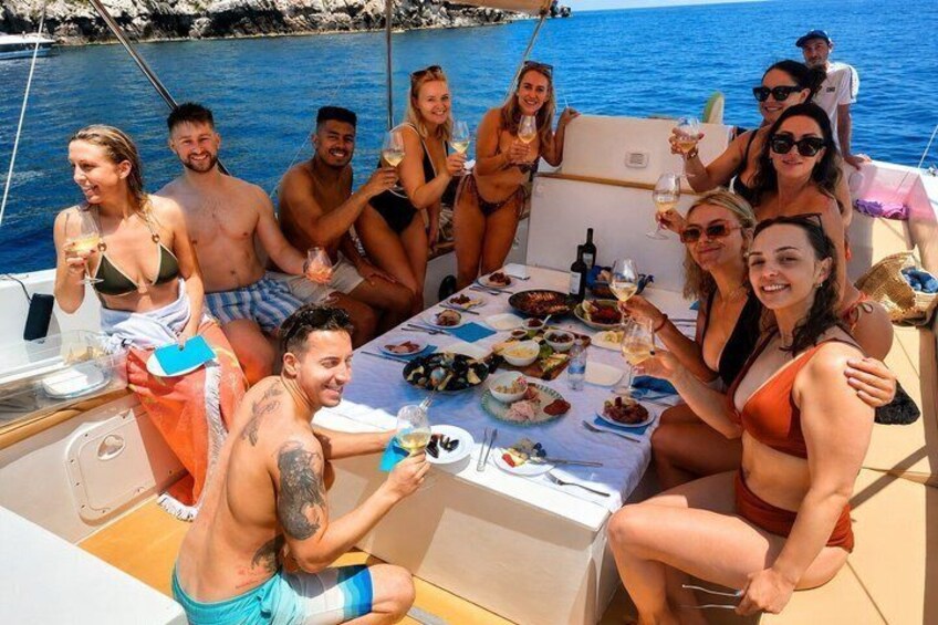 A group of people on a boat with a table set for a meal. 4