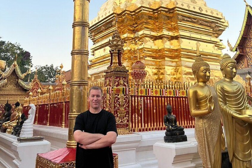 Un homme se tient devant un temple doré, orné de statues et doté d’une architecture complexe. 4
