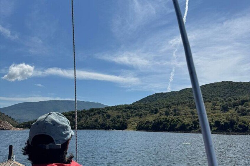 A person on a boat with a mountainous landscape in the background. 3