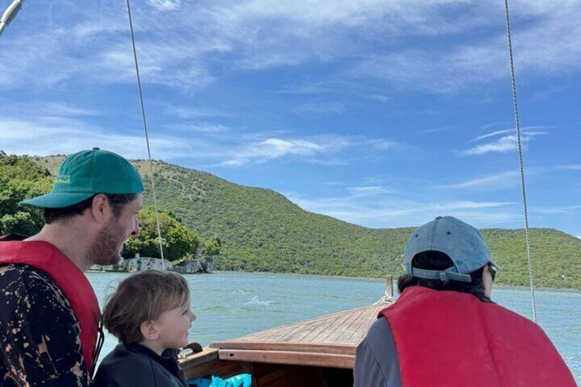 A boat on a lake with a hilly landscape in the background. 2