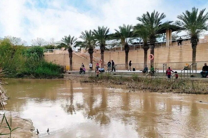 A water body with people walking and sitting on a nearby structure. 5