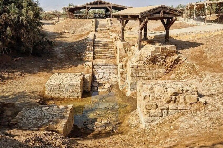 Ancient ruins with stone structures and a wooden walkway. 4