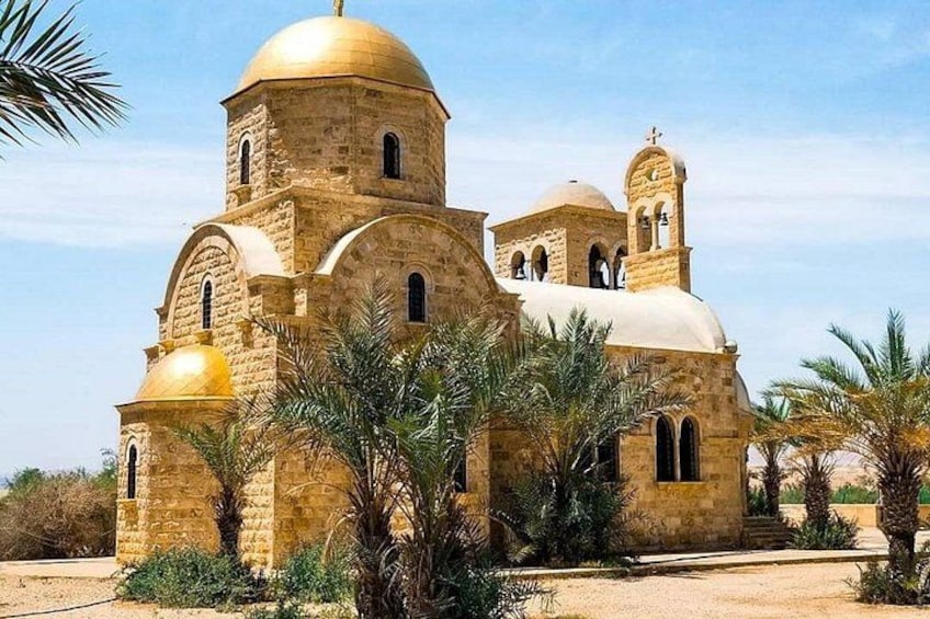 A historic church with domed architecture, surrounded by palm trees. 1