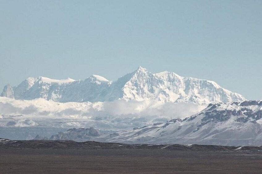 Snow-covered mountains, a clear sky, and a barren landscape. 4