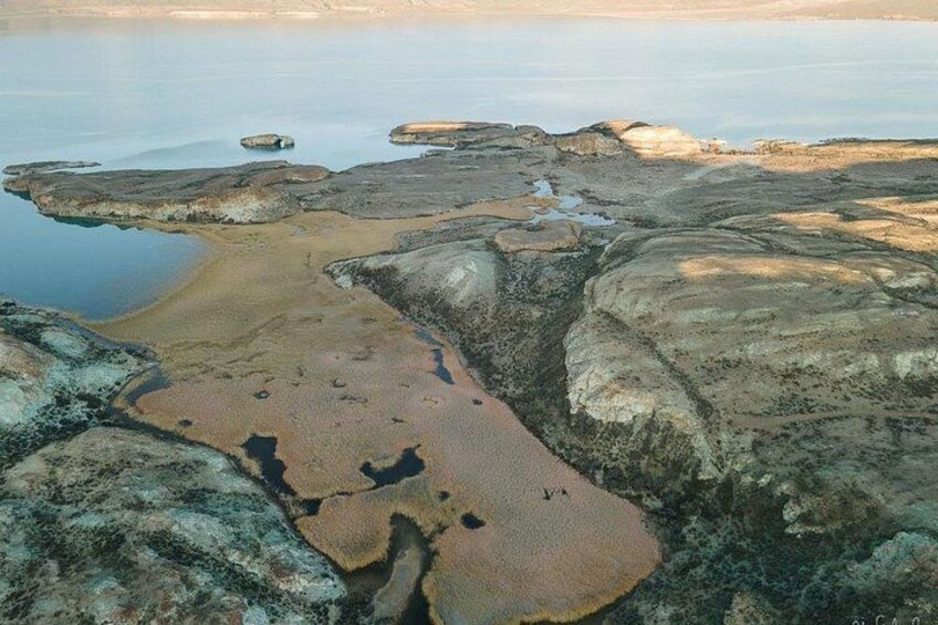 A coastal landscape with rocky terrain and a sandy beach. 5