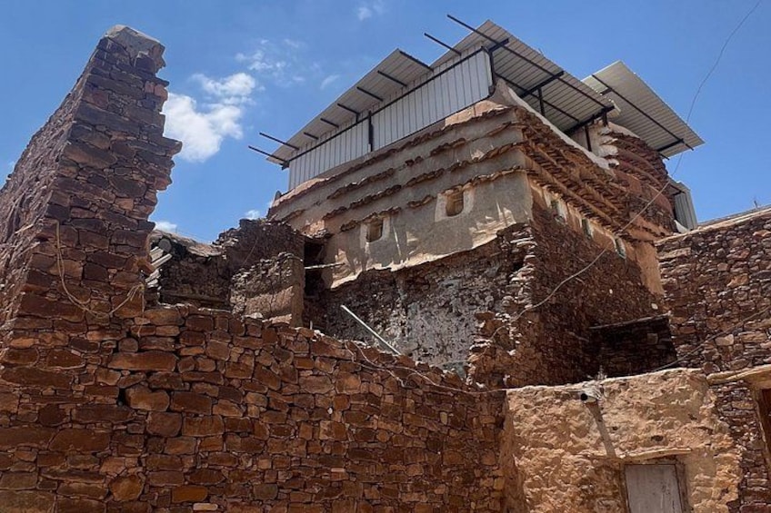 A dilapidated stone building with a partially collapsed roof and a solar panel installation. 4