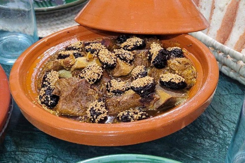 A traditional Moroccan tagine dish served in a clay pot with a lid. 3