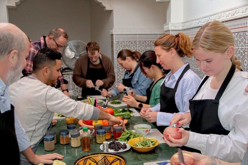 A group of people preparing food in a kitchen with various ingredients and utensils. 4