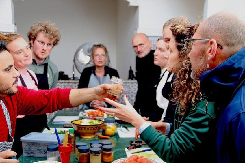 Eine Gruppe von Menschen, die mit Getränken an einem Tisch mit Speisen und Beilagen anstoßen. 4