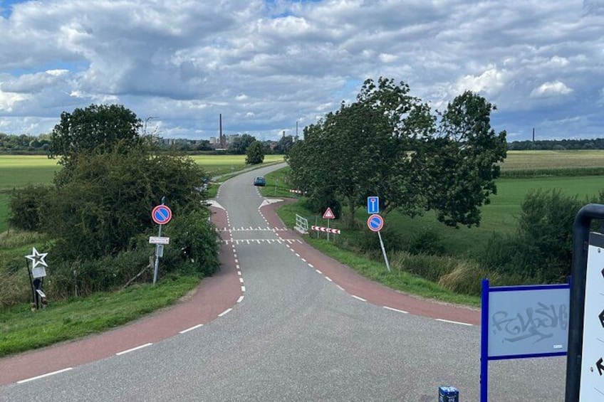 A rural road with a no entry sign, a pedestrian crossing, and a directional sign. 2
