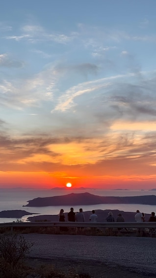 A sunset over a body of water with silhouetted landforms in the distance. 4