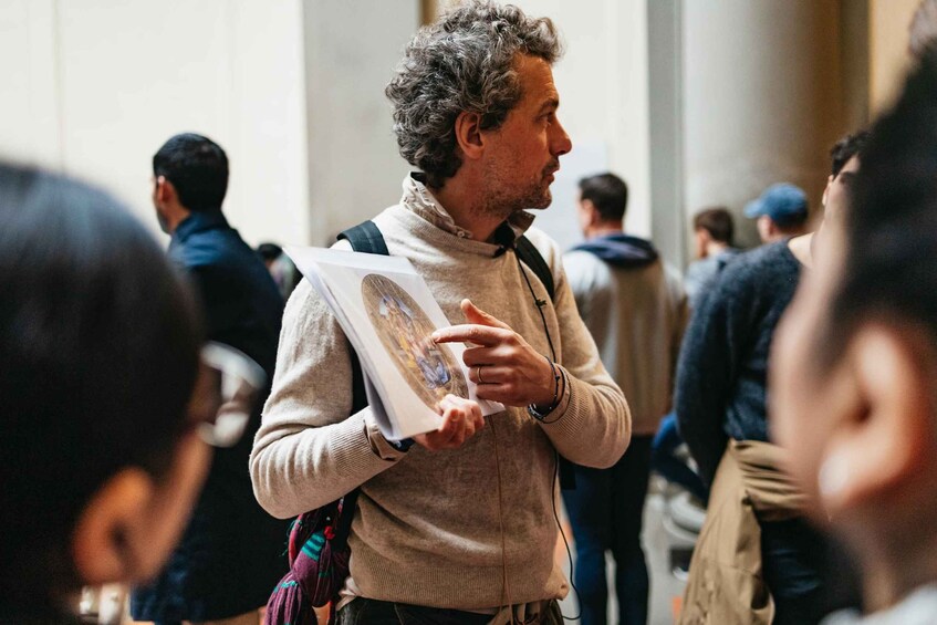 Una persona tiene un libro in un ambiente interno affollato. 2
